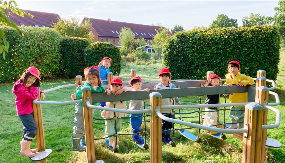 校庭のシーソーで遊ぶ園児