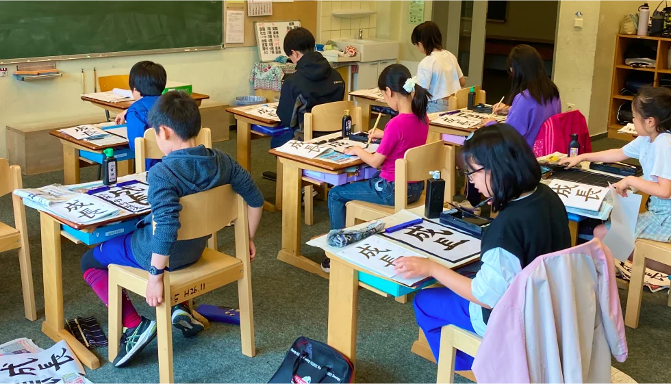 習字の授業をする小学生